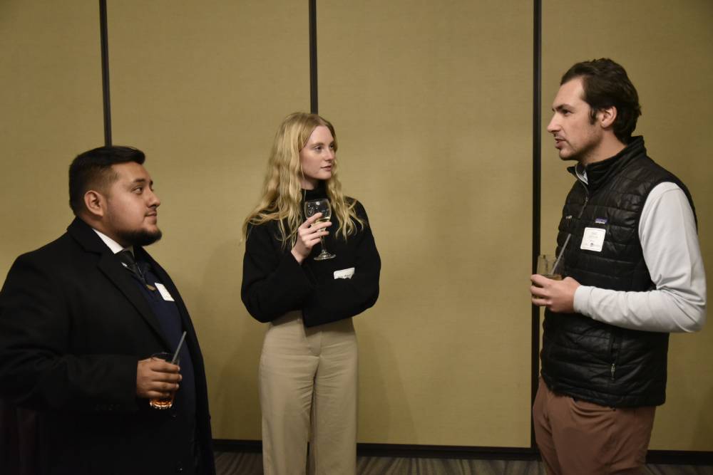 Three Seidman alumni talking at the event.
